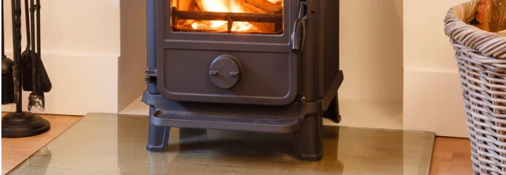 Ein Kaminofen brennt auf einer Glasplatte.